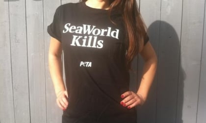 A woman wearing a black t -shirt that says seaworld kills.