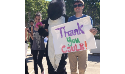 A group of people holding signs that say thank you Csulb