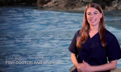 A woman sitting in front of water. Text in the bottom left corner says "Laurie: Fish doctor and stuff"