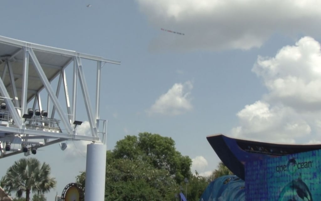 A kite flying over a stage at an amusement park.