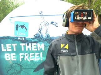 A man wearing headphones looks into a vr headset