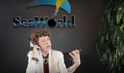 Lily Tomlin is talking on the phone with a spoof seaworld logo in the background