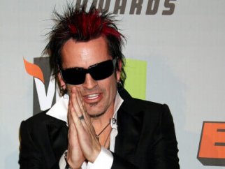 Tommy Lee posing on a red carpet.