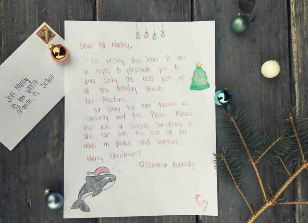 A letter with a christmas tree and ornaments on it.