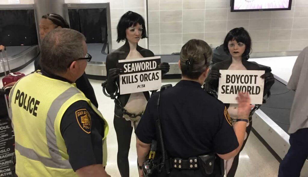 A group of people holding signs at an airport.