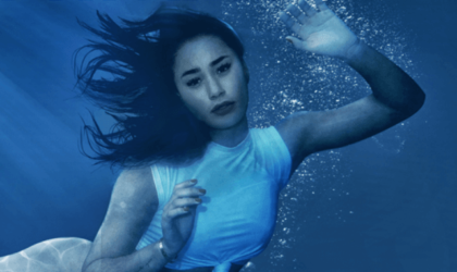 PETA ad with influencer Eva Gutowski submerged in a tiny tank as if at SeaWorld, with the words "This is no place for animals."